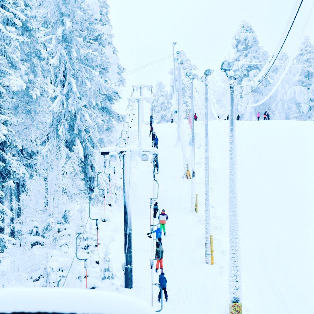 Lasketteluhississä olevia ihmisiä Äänemäen laskettelurinteessä.