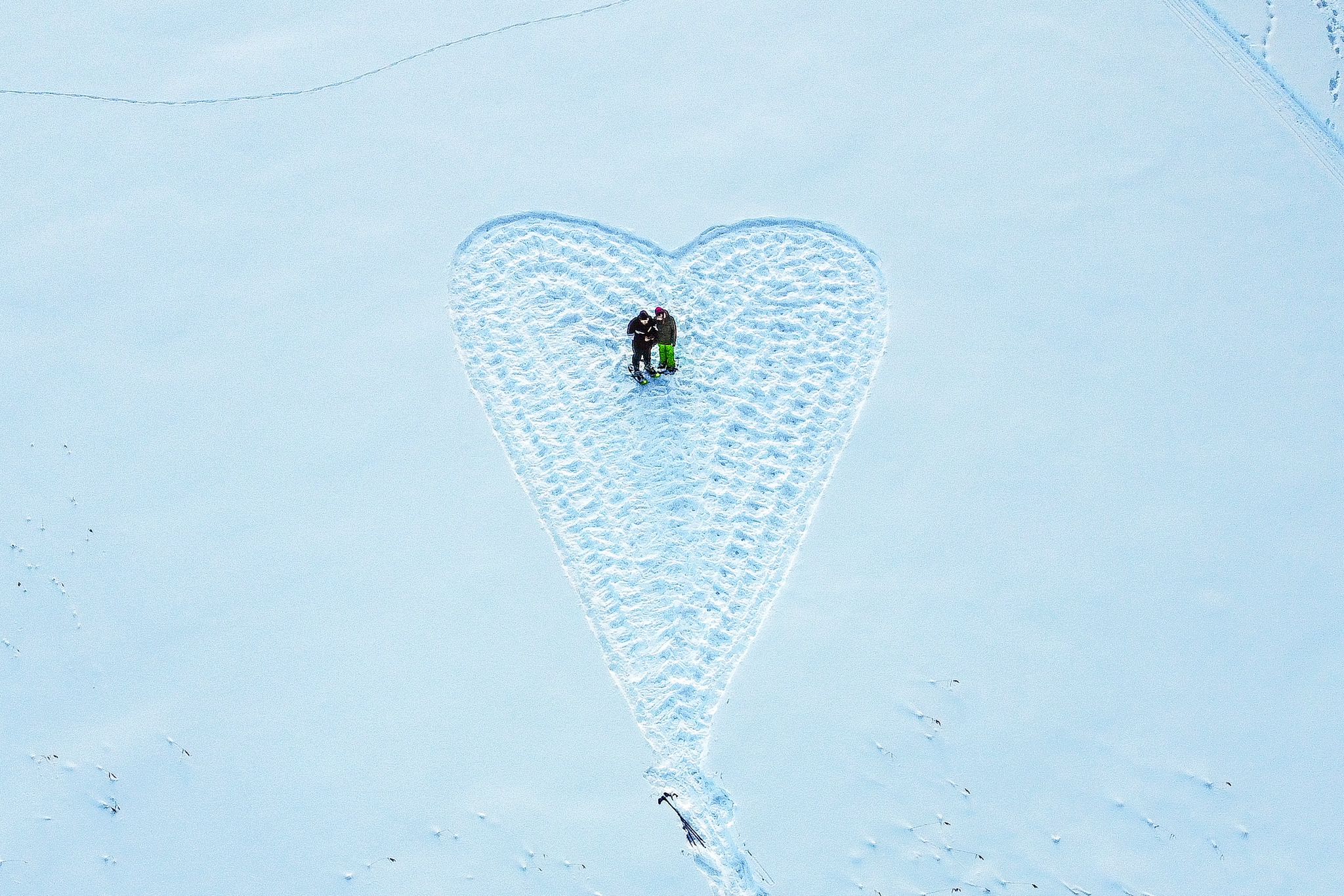 Lumikengillä tampattu sydän jäällä.
