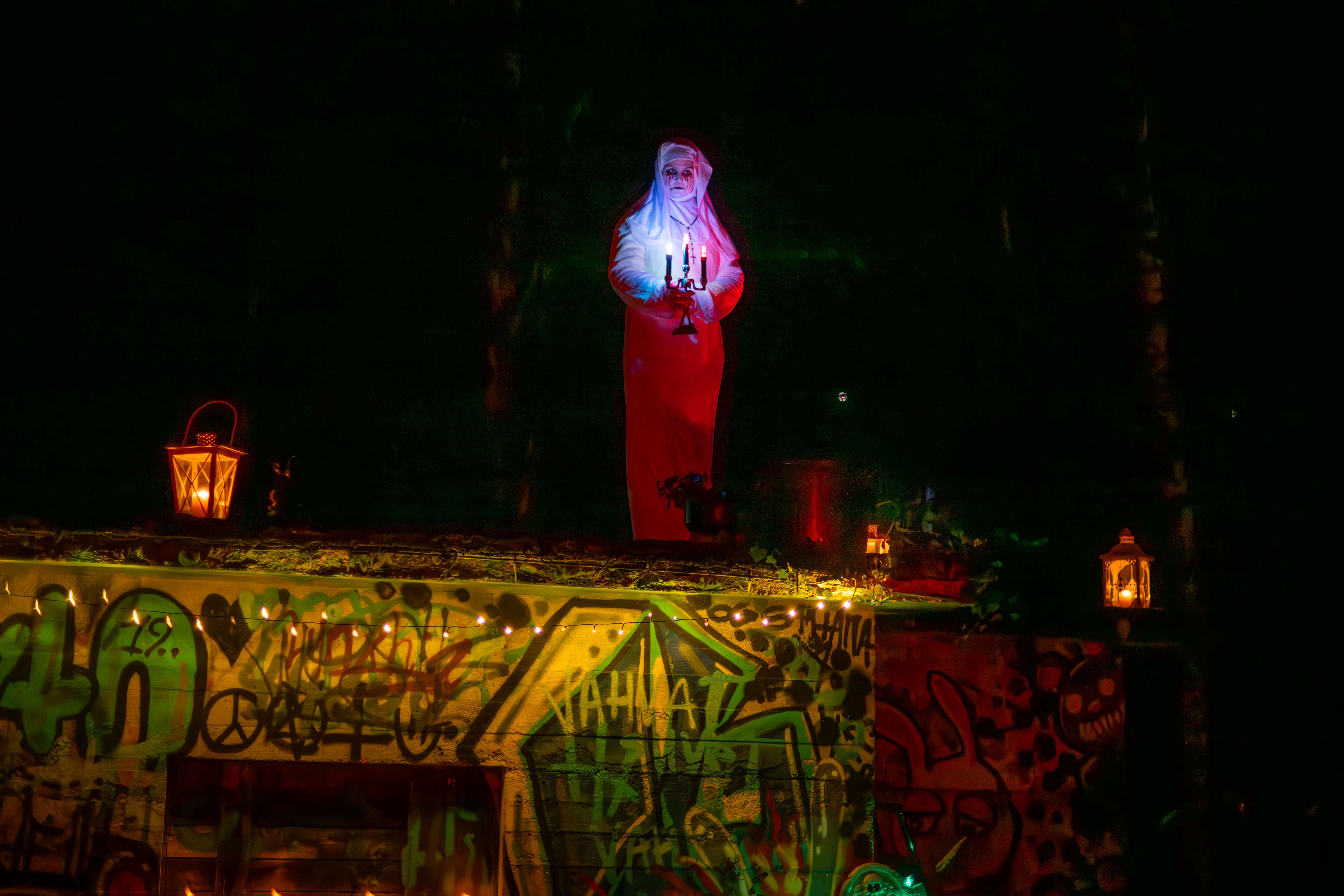 Halloween-asuun pukeutunut henkilö ja halloween-koristeita