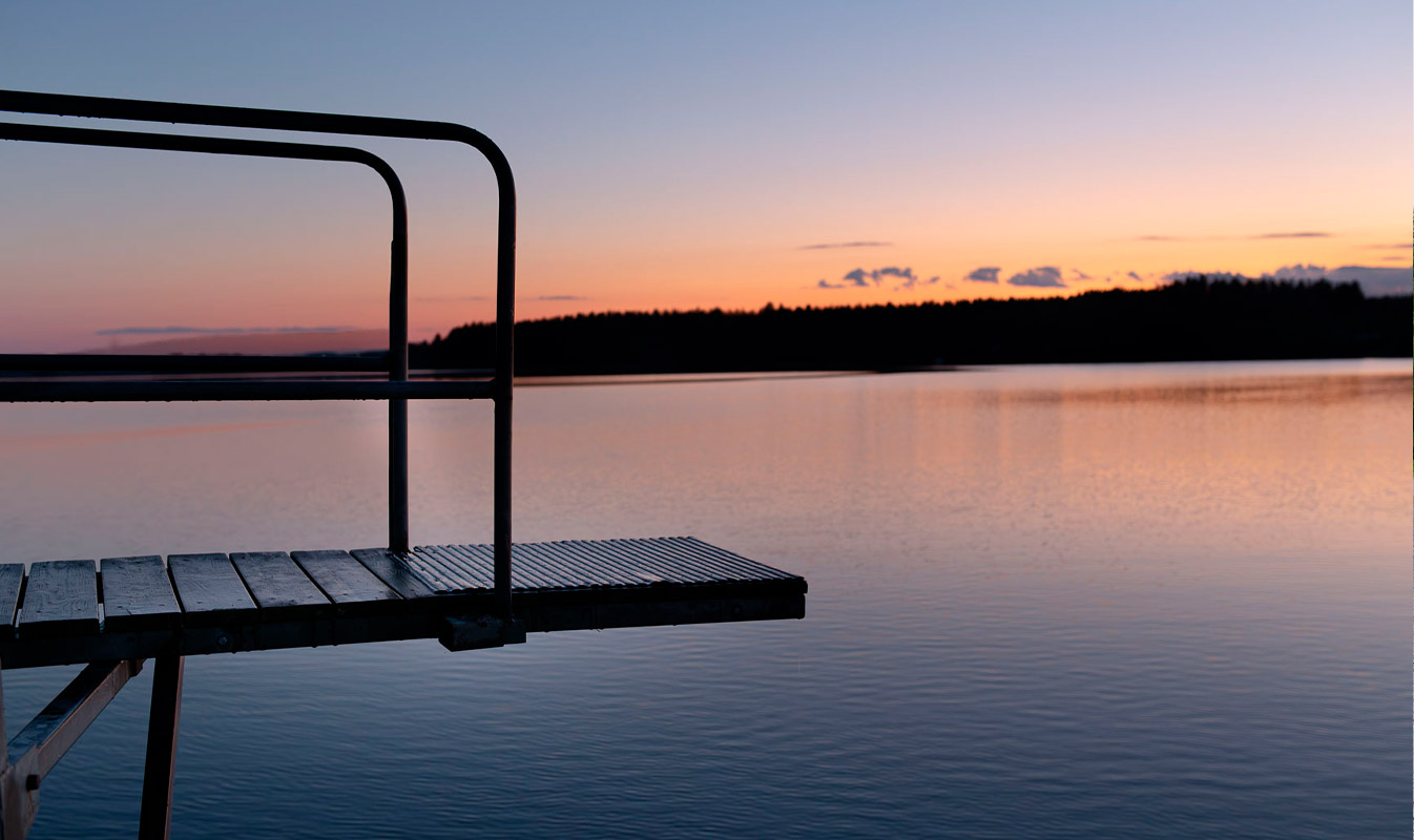Lossin uimarannan hyppytorni, taustalla tyyni järvi.