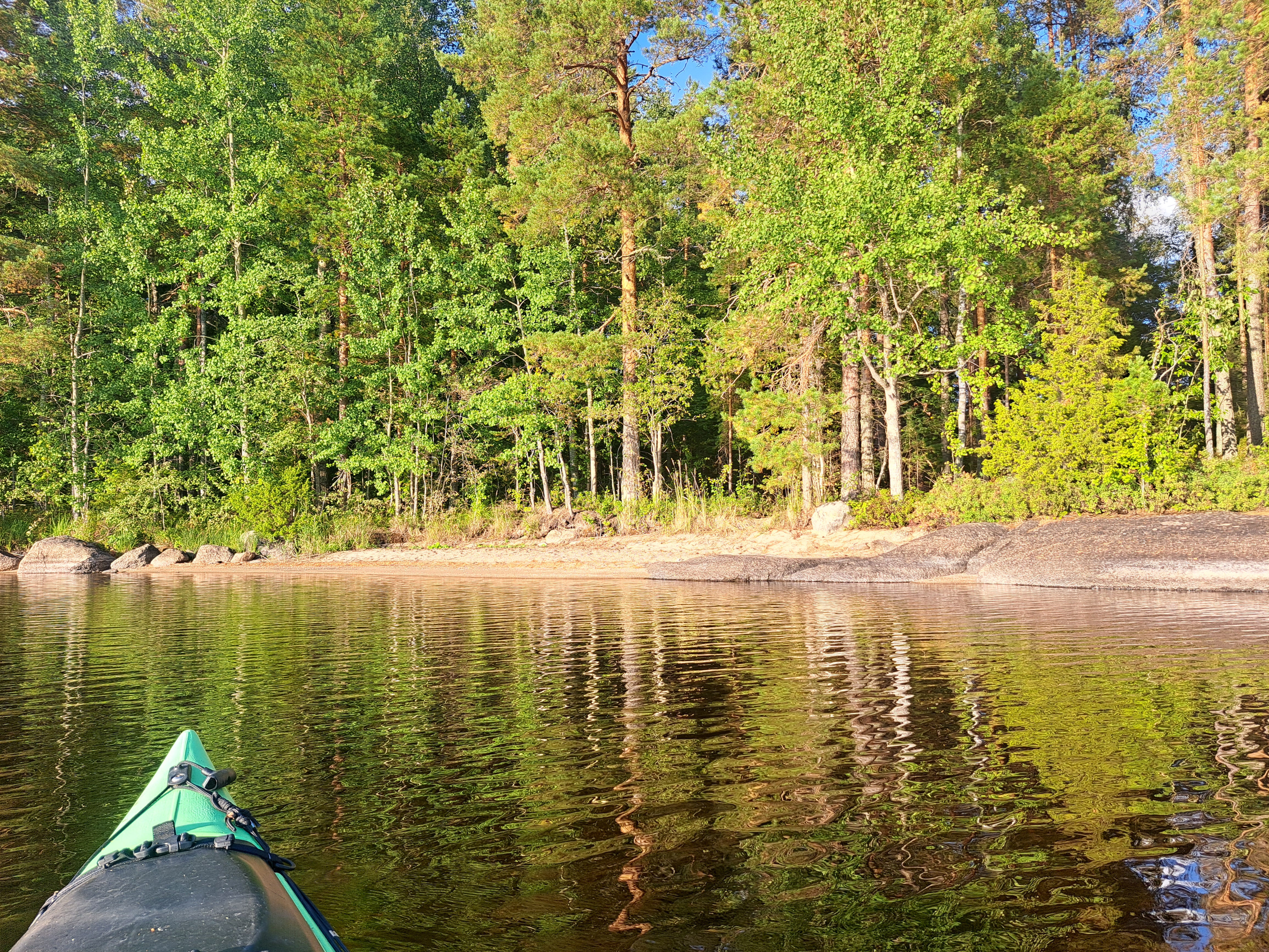 Kajakin keula lähestymässä hiekkarantaa.