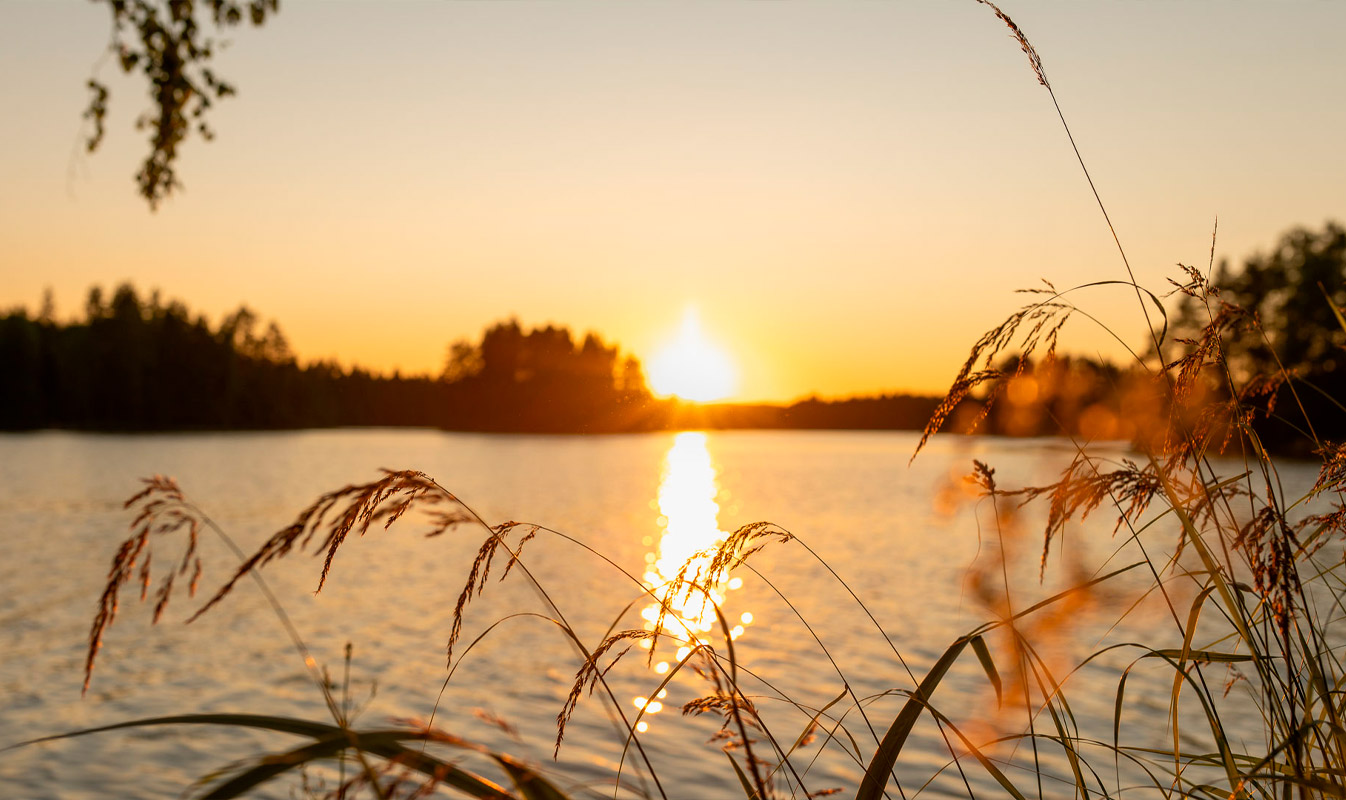 Jouluisasti sisustetussa tilasta lähikuva. Etualalla tuoli, jossa tyynyjä ja kankaita. Taaempana pöytä, jossa pöytäliina, kirjoja ja joulukoristeita.