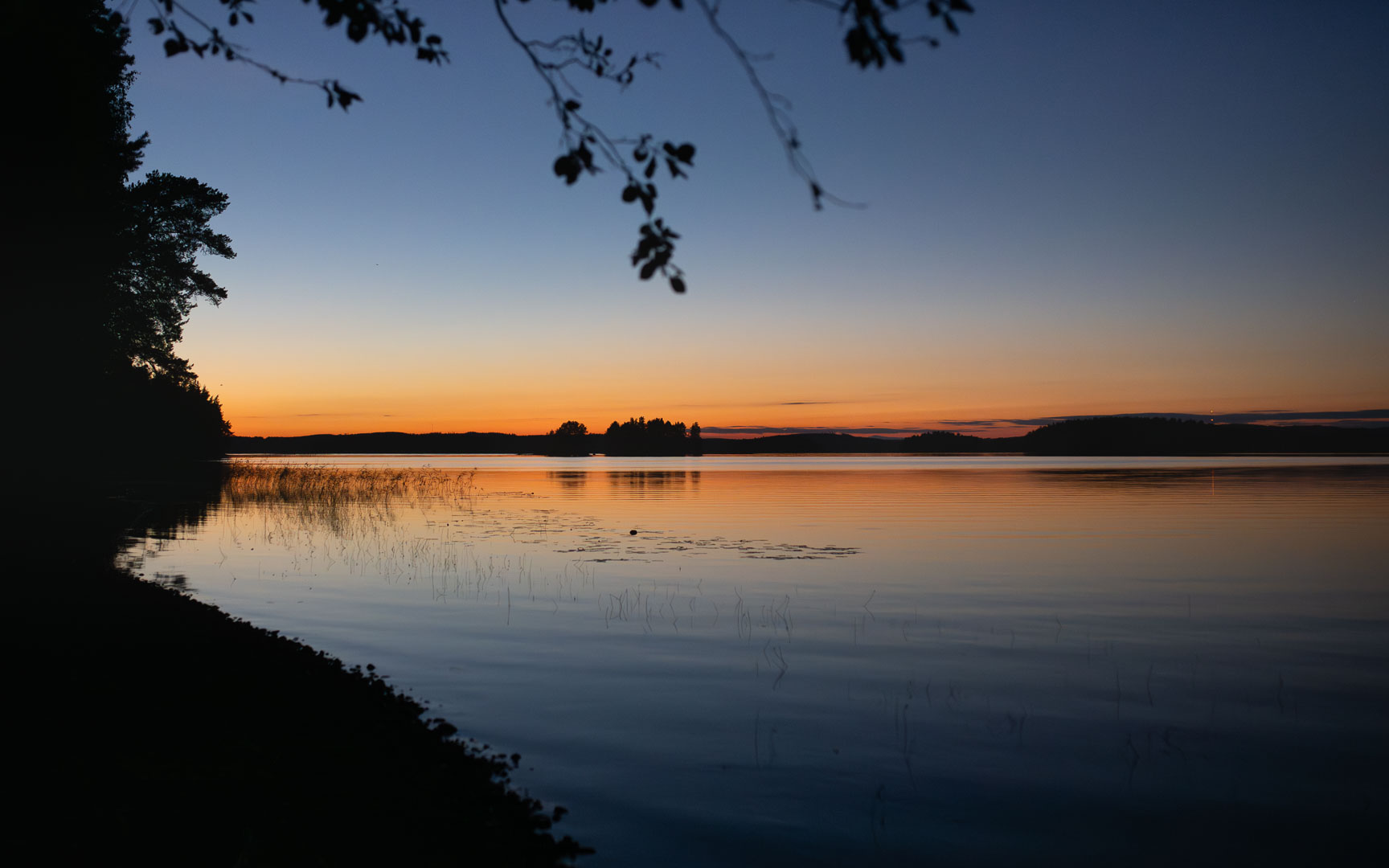 Tyyni järvimaisema auringonlaskun jälkeen