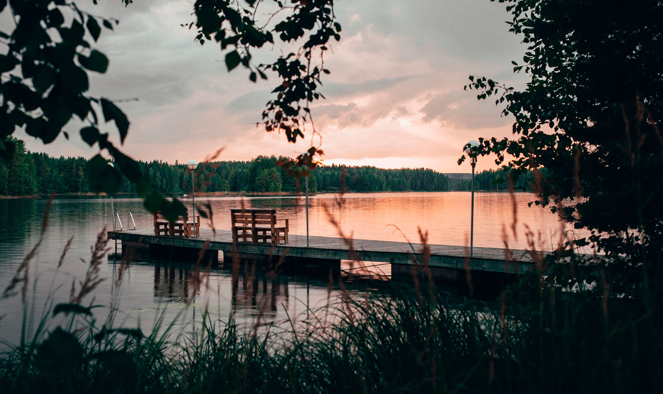 Henkilö istuu metsässä juoden lämmintä.