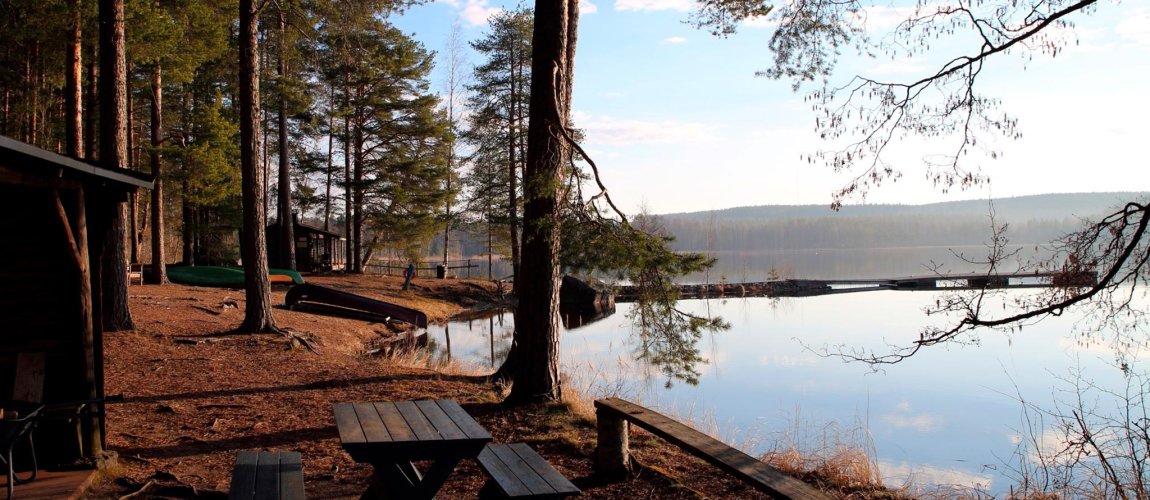Rantamaisema: tyyni järvi, jonka rannassa soutuvene.